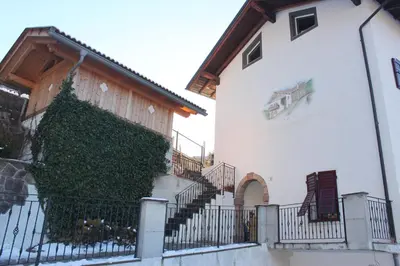 a building with a green plant on the side of it at Mas dal Vent in Valfloriana