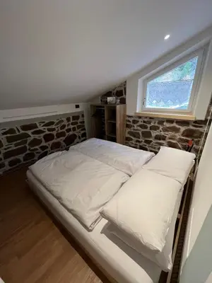 a bed with pillows in a room with a window at Mas dal Vent in Valfloriana