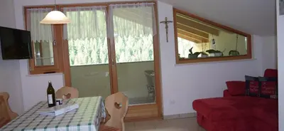 a living room with a table and a red couch at Ferienwohnung Matzhof in Nova Levante