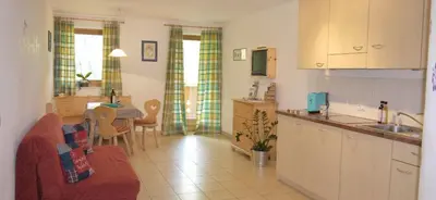 a kitchen and living room with a couch and a table at Ferienwohnung Matzhof in Nova Levante