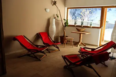 a living room with three red chairs and a table at Ferienwohnung Matzhof in Nova Levante