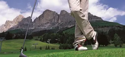 a person standing in a field with a golf club at Ferienwohnung Matzhof in Nova Levante