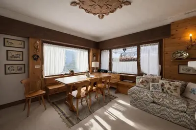 a dining room with a table and a couch at Ca La Casetta in Cortina dʼAmpezzo