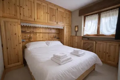 a bedroom with a bed with towels on it at Ca La Casetta in Cortina dʼAmpezzo