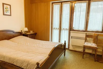 a bedroom with a bed and a large window at Casa a Penia-Alba a 2 minuti da impianti funivia in Penia