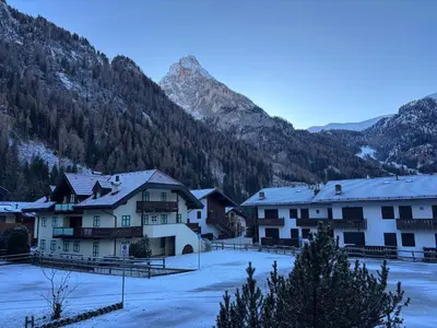 a group of buildings with mountains in the background at Casa a Penia-Alba a 2 minuti da impianti funivia in Penia