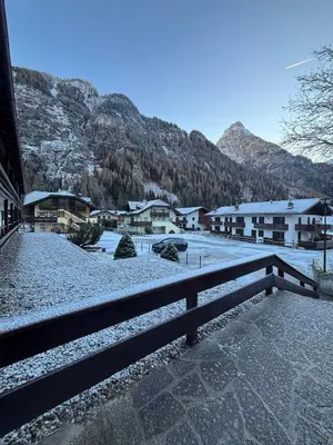 a snow covered town with houses and a mountain at Casa a Penia-Alba a 2 minuti da impianti funivia in Penia