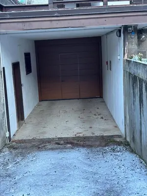 a garage with a wooden door in a building at Casa a Penia-Alba a 2 minuti da impianti funivia in Penia