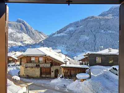a house in the mountains with snow on the ground at La Perla di Fassa - Alpine Stay Apartments in Moena