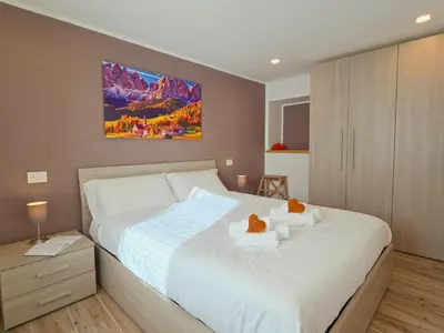 a bedroom with a bed with two teddy bears on it at La Perla di Fassa - Alpine Stay Apartments in Moena