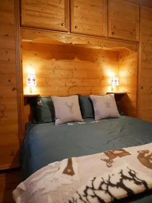 a bedroom with a bed in a wooden room at Appartamento Val Di Roda in San Martino di Castrozza