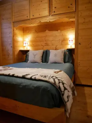 a bedroom with a bed in a log cabin at Appartamento Val Di Roda in San Martino di Castrozza