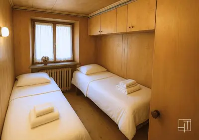 two beds in a small room with a window at HT - Esclusivo chalet a Cortina d'Ampezzo in Cortina dʼAmpezzo