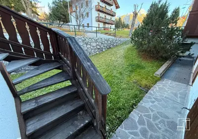 a wooden bench sitting next to a building at HT - Esclusivo chalet a Cortina d'Ampezzo in Cortina dʼAmpezzo