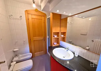 a bathroom with a sink and a toilet and a mirror at HT - Esclusivo chalet a Cortina d'Ampezzo in Cortina dʼAmpezzo