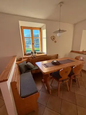 a kitchen with a wooden table and a table and chairs at Appartamento Centro del Fondo Lago di Tesero in Tesero