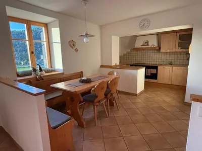 a kitchen with a table and chairs in a kitchen at Appartamento Centro del Fondo Lago di Tesero in Tesero