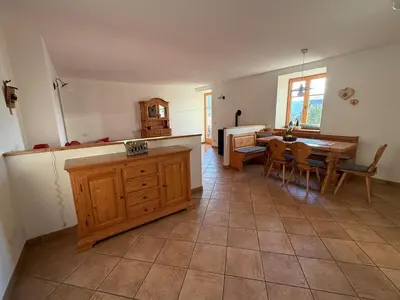 a kitchen with a table and a dining room at Appartamento Centro del Fondo Lago di Tesero in Tesero