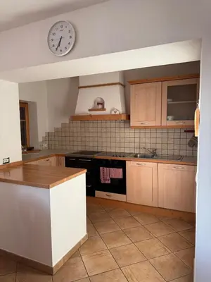 a kitchen with a clock on the wall at Appartamento Centro del Fondo Lago di Tesero in Tesero