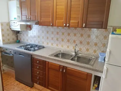a kitchen with a sink and a stove at Appartamento Rosa in Predazzo