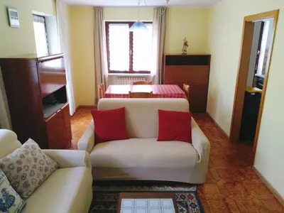 a living room with two beds and a couch at Appartamento Rosa in Predazzo