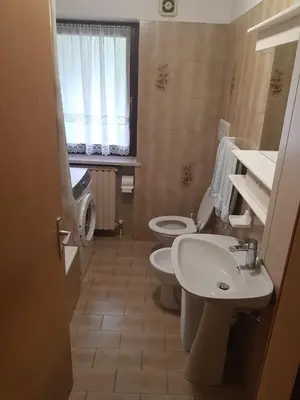 a small bathroom with two toilets and a sink at Appartamento Rosa in Predazzo