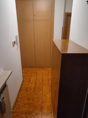 a kitchen with wooden cabinets and a wooden floor at Appartamento Rosa in Predazzo