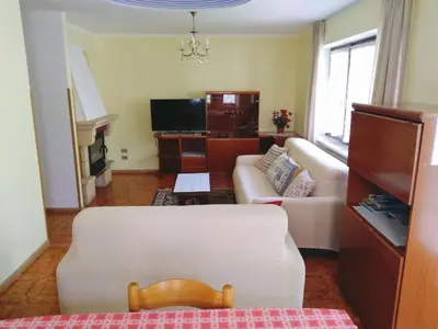 a living room with a white couch and a tv at Appartamento Rosa in Predazzo