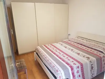 a bedroom with two beds and a closet at Appartamento Rosa in Predazzo