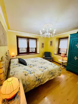 a bedroom with a bed and a chandelier at Trilli House in Rocca Pietore