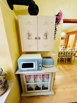 a microwave sitting on a table with a cabinet at Trilli House in Rocca Pietore