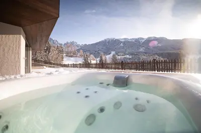 a hot tub with a view of the mountains at Trutscher Häusl in Villnöss - Chalet in den Dolomiten mit Blick auf die Geisler in Funes