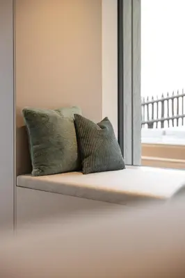 a couch with two pillows on it in front of a window at Trutscher Häusl in Villnöss - Chalet in den Dolomiten mit Blick auf die Geisler in Funes