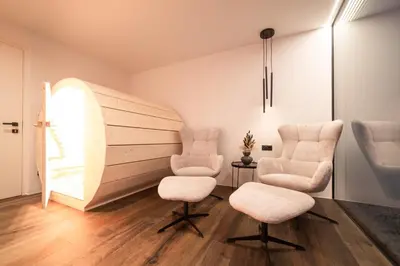 a living room with two chairs and a table at Trutscher Häusl in Villnöss - Chalet in den Dolomiten mit Blick auf die Geisler in Funes