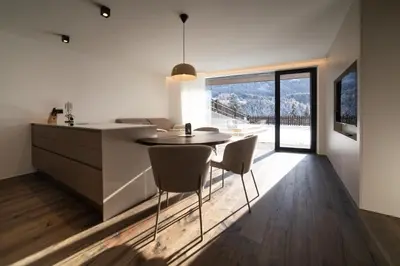 a kitchen and dining room with a table and chairs at Trutscher Häusl in Villnöss - Chalet in den Dolomiten mit Blick auf die Geisler in Funes