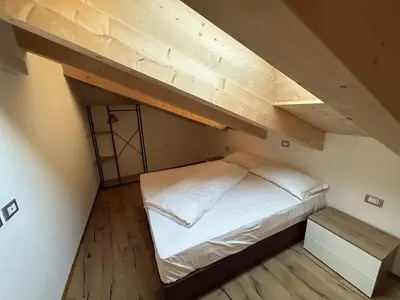 a bed in a room with a loft at Lago House in Tesero