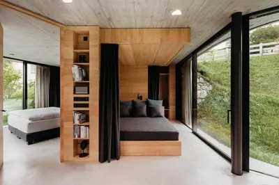 a bedroom with a bed and large glass windows at Freiform Private Guesthouse in Chiusa