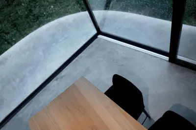 a table and a chair in front of a window at Freiform Private Guesthouse in Chiusa