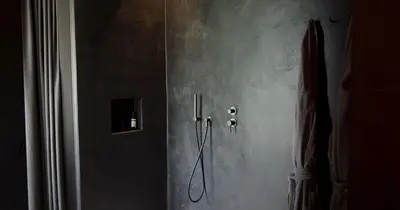 a bathroom with a hose hooked up to a wall at Freiform Private Guesthouse in Chiusa