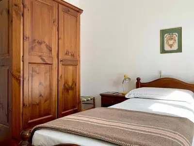 a bedroom with a bed and a wooden cabinet at Apartment in the Center of Cortina in Cortina dʼAmpezzo