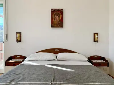 a bedroom with a bed with a painting on the wall at Apartment in the Center of Cortina in Cortina dʼAmpezzo