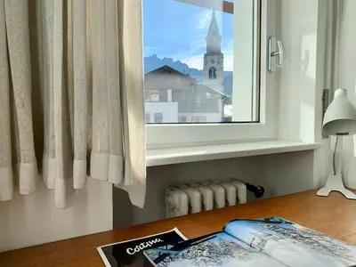 a window with a view of a church at Apartment in the Center of Cortina in Cortina dʼAmpezzo