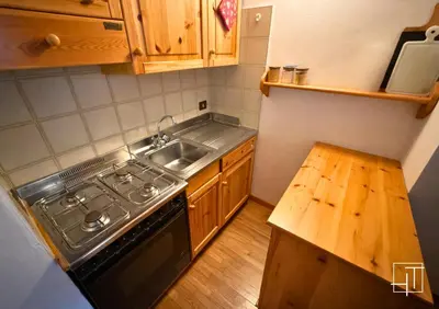 a small kitchen with a stove and a sink at HT - Mansarda panoramica nel cuore di San Vito in San Vito di Cadore