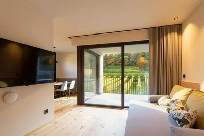 a living room with a white couch and a sliding glass door at Maratscherhof in Eppan an der Weinstrasse ST. Pauls