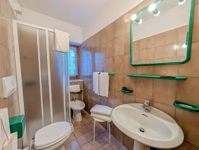 a bedroom with a bed and a large window at Hotel Patri in Sottoguda