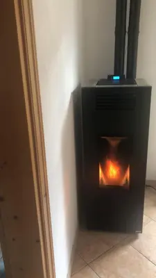 a fireplace in the corner of a room at Fontanelle La Casa Dei Nonni in Elmo