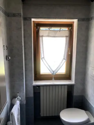 a bathroom with a toilet and a window at Fontanelle La Casa Dei Nonni in Elmo