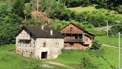 an old stone house on a green hillside at Fontanelle La Casa Dei Nonni in Elmo