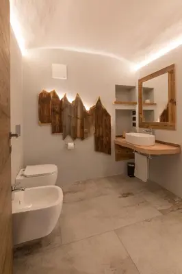 a bathroom with a toilet and a sink and a mirror at Latemar Fiemme Apartments 1 in Tesero