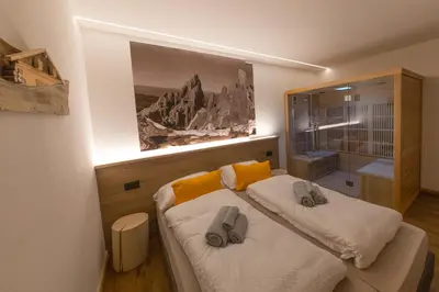a bedroom with a bed with two slippers on it at Latemar Fiemme Apartments 1 in Tesero